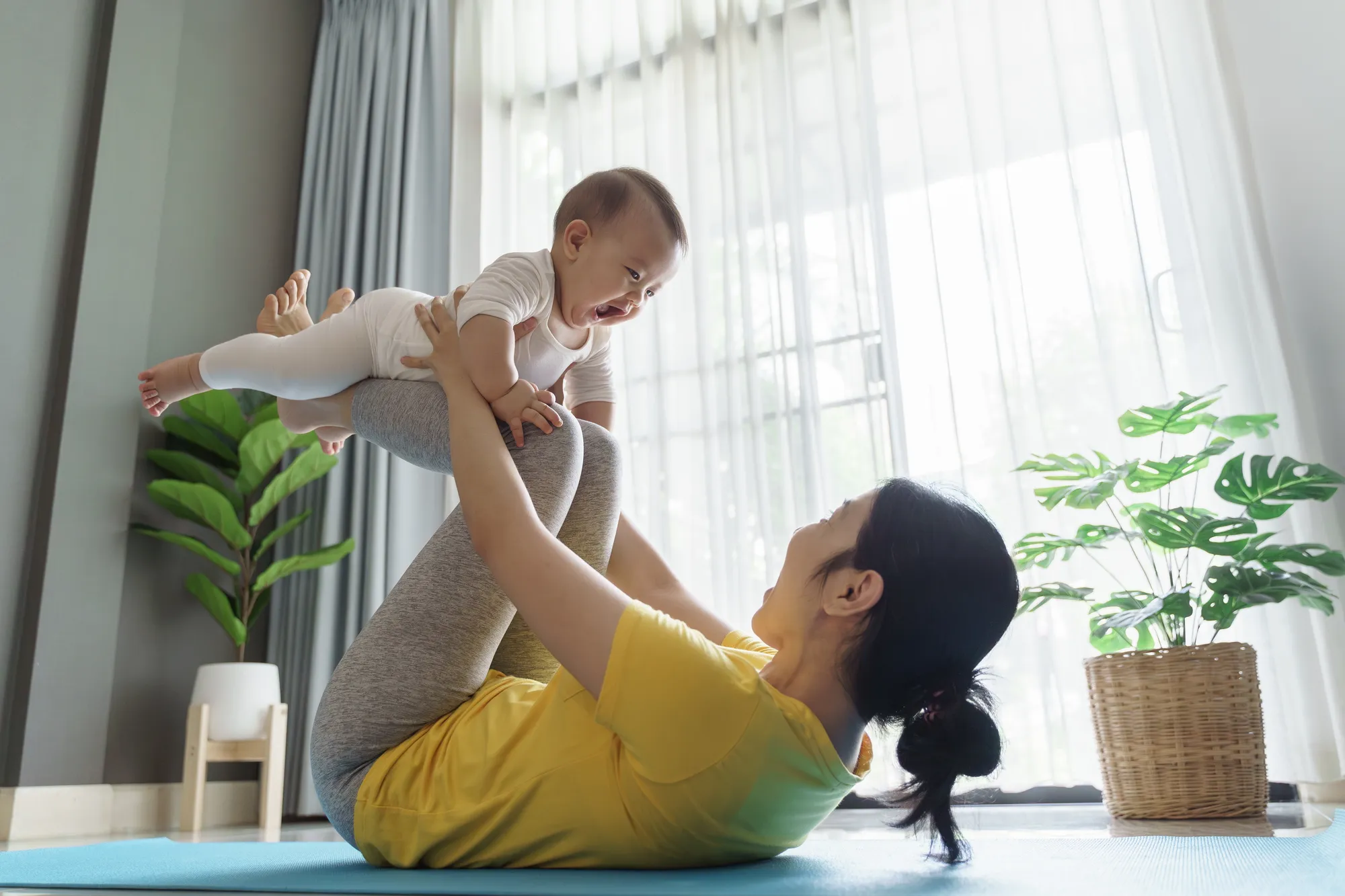 Asian mother lifting baby during exercise