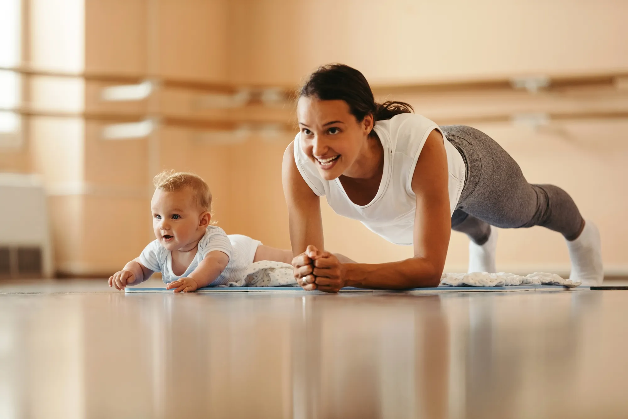 Athletic mother exercising with baby