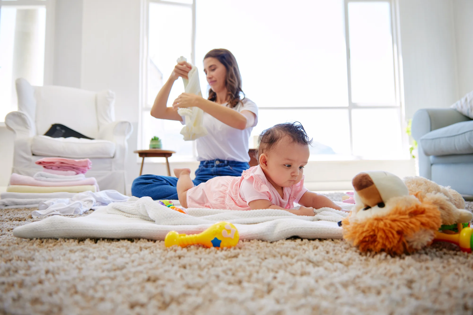 Parent cheering on newborn during floor-based tummy time practice
