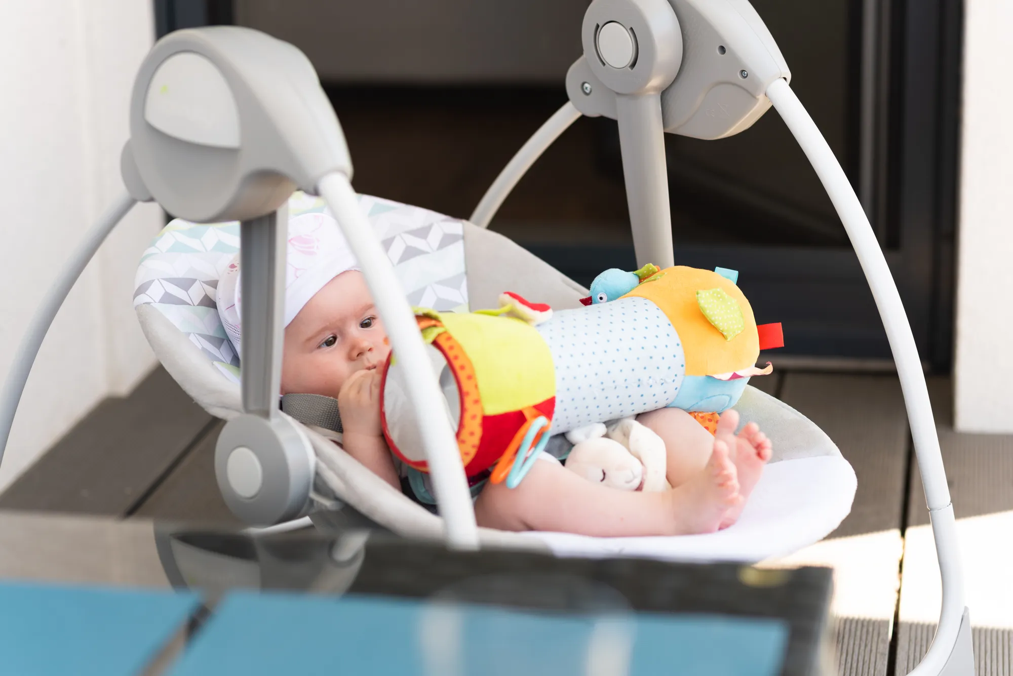 Baby in electric swing outdoors