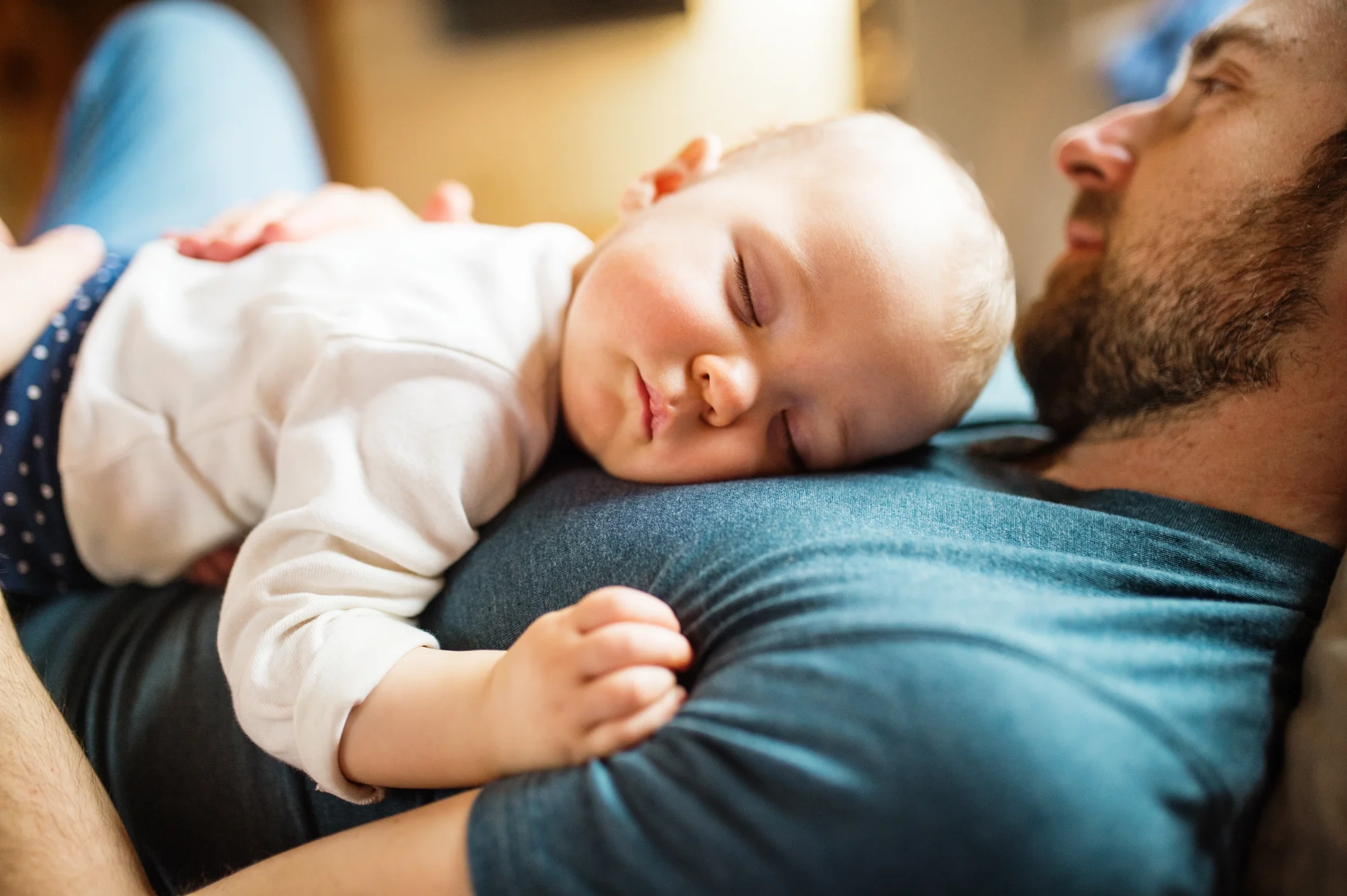 Father cuddling newborn chest-to-chest during quiet bonding time