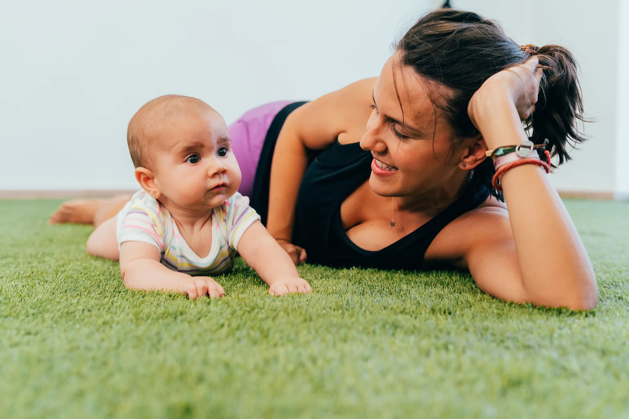 Mother creating a safe floor setup for newborn movement practice