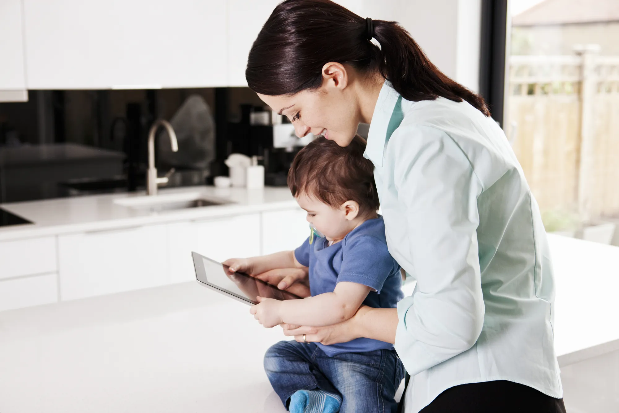 Mother and baby looking at digital tablet
