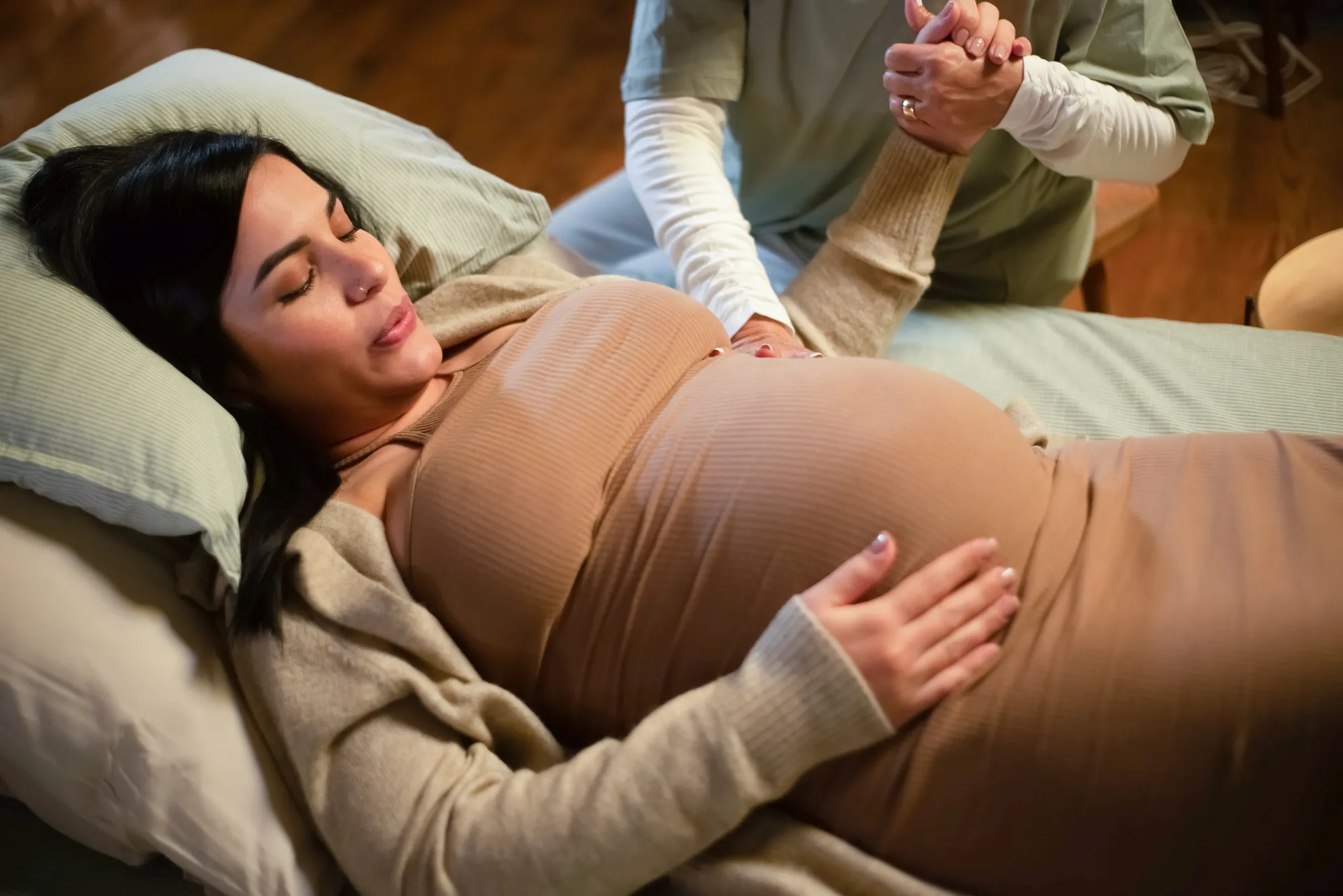Pregnant woman with midwife at home providing supportive care