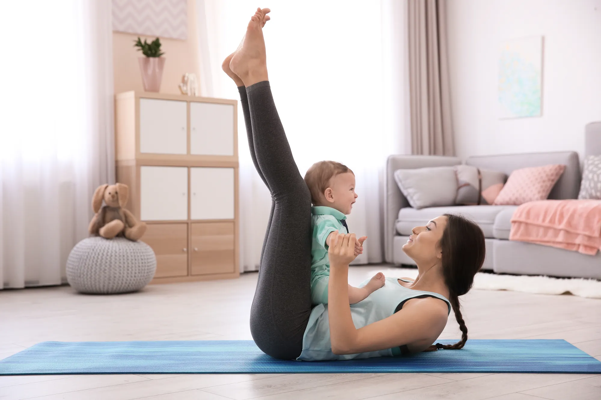 Young mother doing yoga with baby